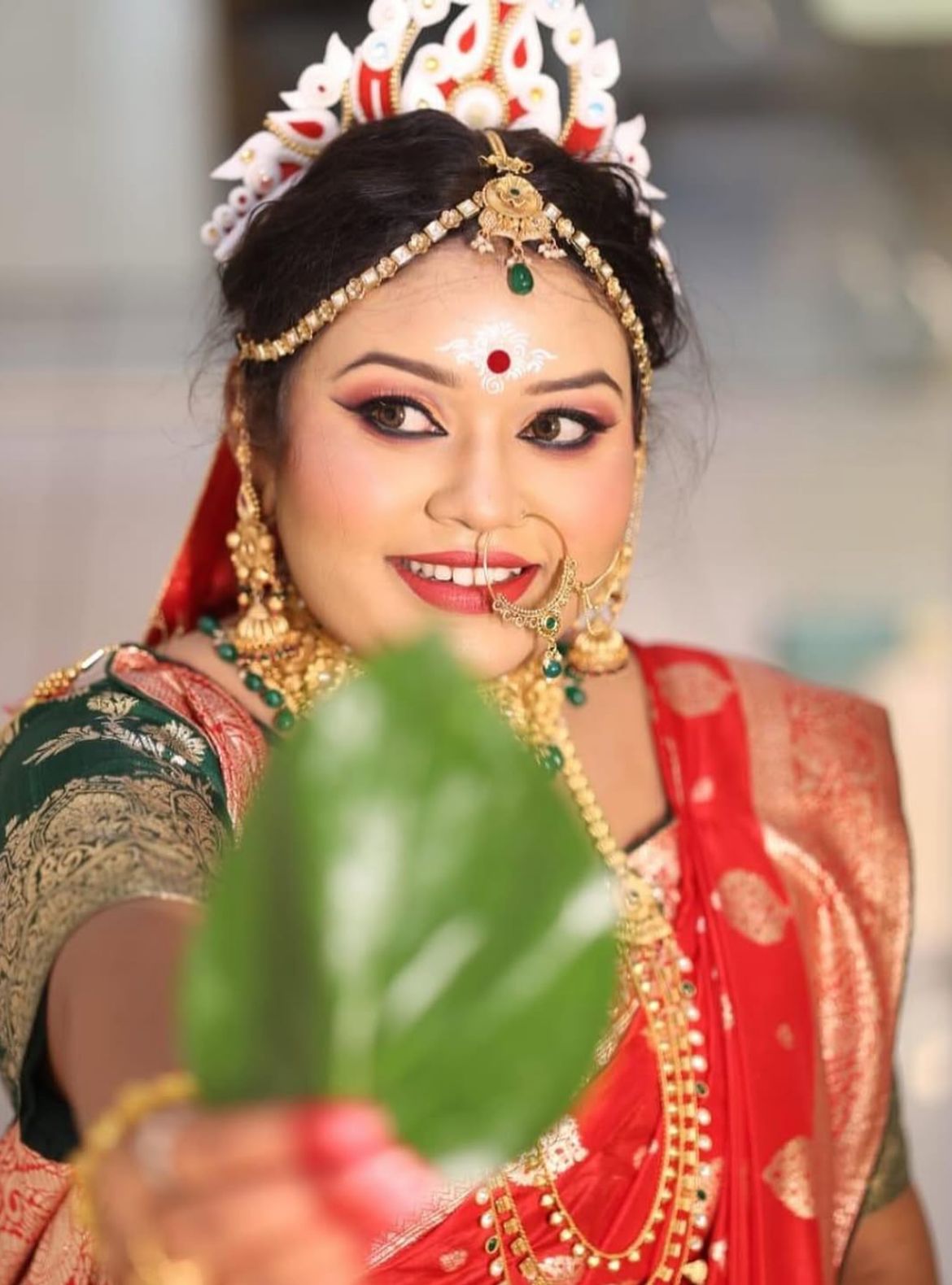 A flawless Bengali bridal look featuring traditional details by Glamvibe.